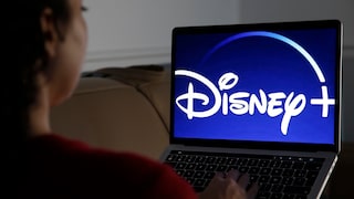 Frau guckt Disney+ auf dem Fernseher