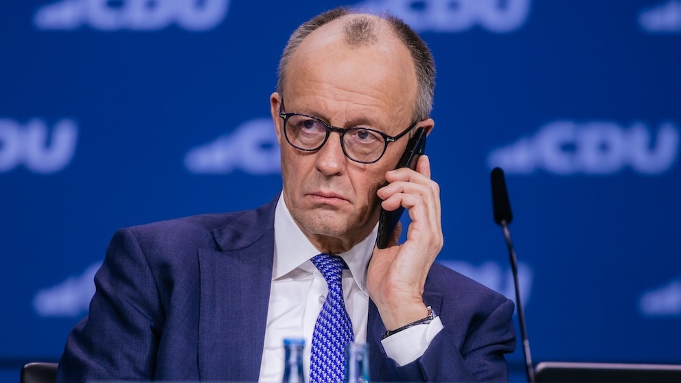 Bundeskanzler Friedrich Merz telefoniert mit seinem Smartphone
