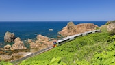 Rund um die Welt gibt es atemberaubende Bahnstrecken. Im Bild zu sehen: Ein Zug der Gonō Line in Japan, der im Norden des Landes an der Küste entlangfährt.