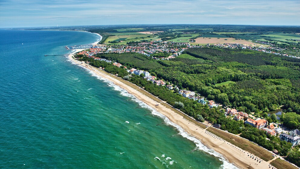 Der lange Strand samt Promenade, dazu im Hintergrund der Stadtwald – Kühlungsborn ist eine heiße Perle an der Ostsee