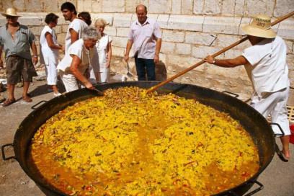 Lernerfolgskontrolle: Was macht der Mann auf dem Bild falsch? Allerdings: Dies ist auch kein Kochkurs, sondern ein Weinfest in Palma. Und vielleicht dient der XXXL-Kochlöffel auch einzig zum Portionieren