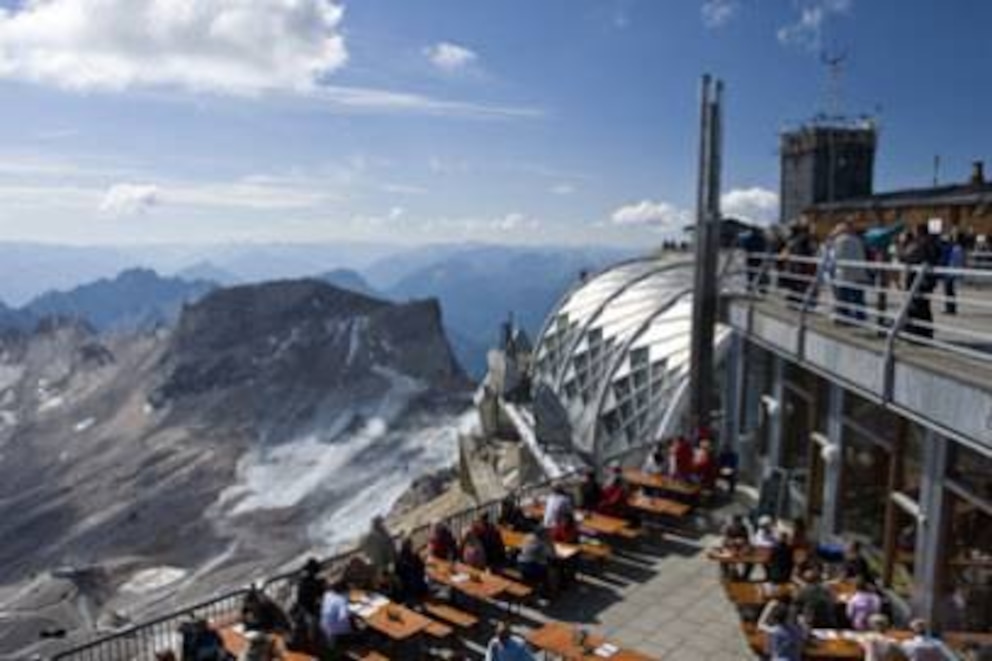 Bei Speisen oder einem kühlen Bier kann man vom Gipfel der Zugspitze aus das Panorama genießen