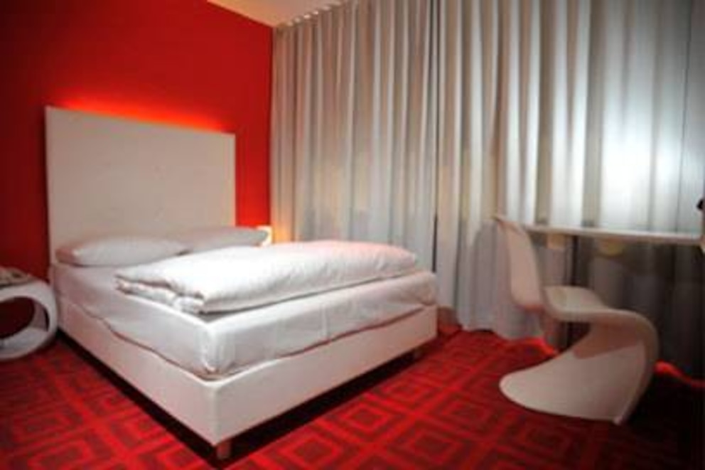 Das Zimmer ist schlicht in Rot- und Weiß-Tönen gehalten