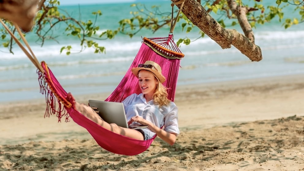 Digital Nomads: Frau liegt in Hängematte mit LapTop