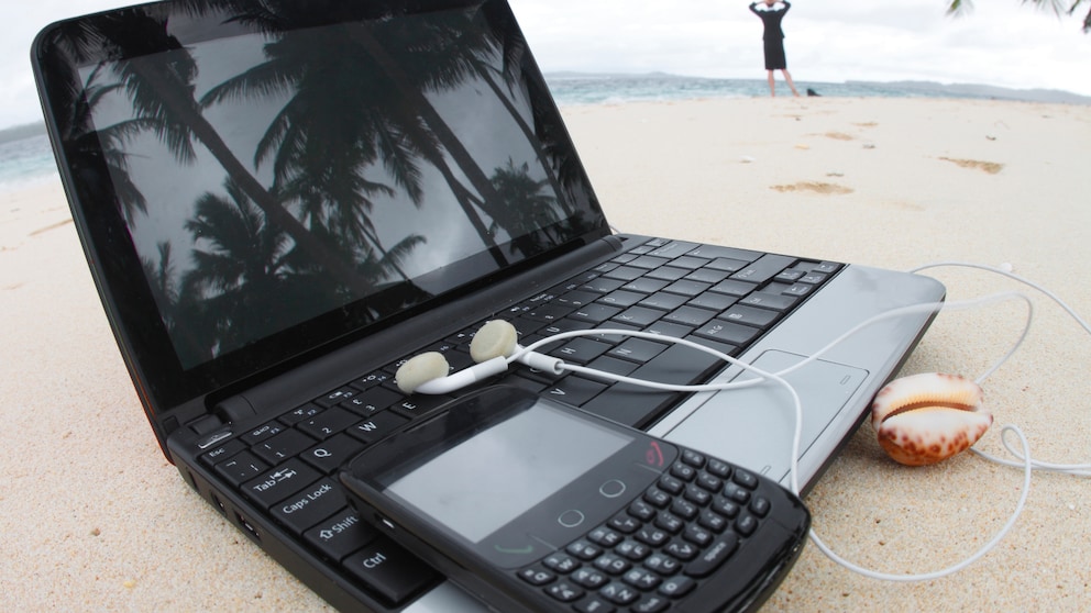 Laptop und Handy am Strand