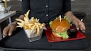 Sie sind spät dran und schaffen es vor Abflug nur noch schnell in den Fastfood-Imbiss? Ungünstig! Denn Pommes und Co. sollten Sie jetzt EIGENTLICH nicht essen...