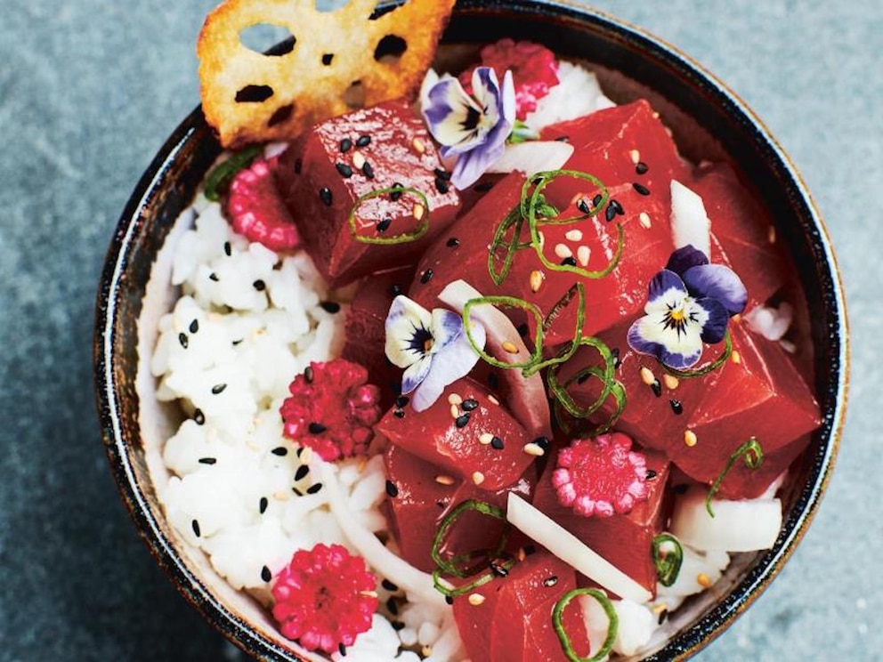 Eine traditionelle Poke-Bowl mit Thunfisch, Reis, frittierter Lotuswurzel, eingelegtem Maiskolben und essbaren Bl&uuml;ten