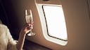 Frau trinkt Champagner im Flugzeug
