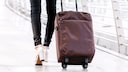 Frau am Flughafen mit Koffer