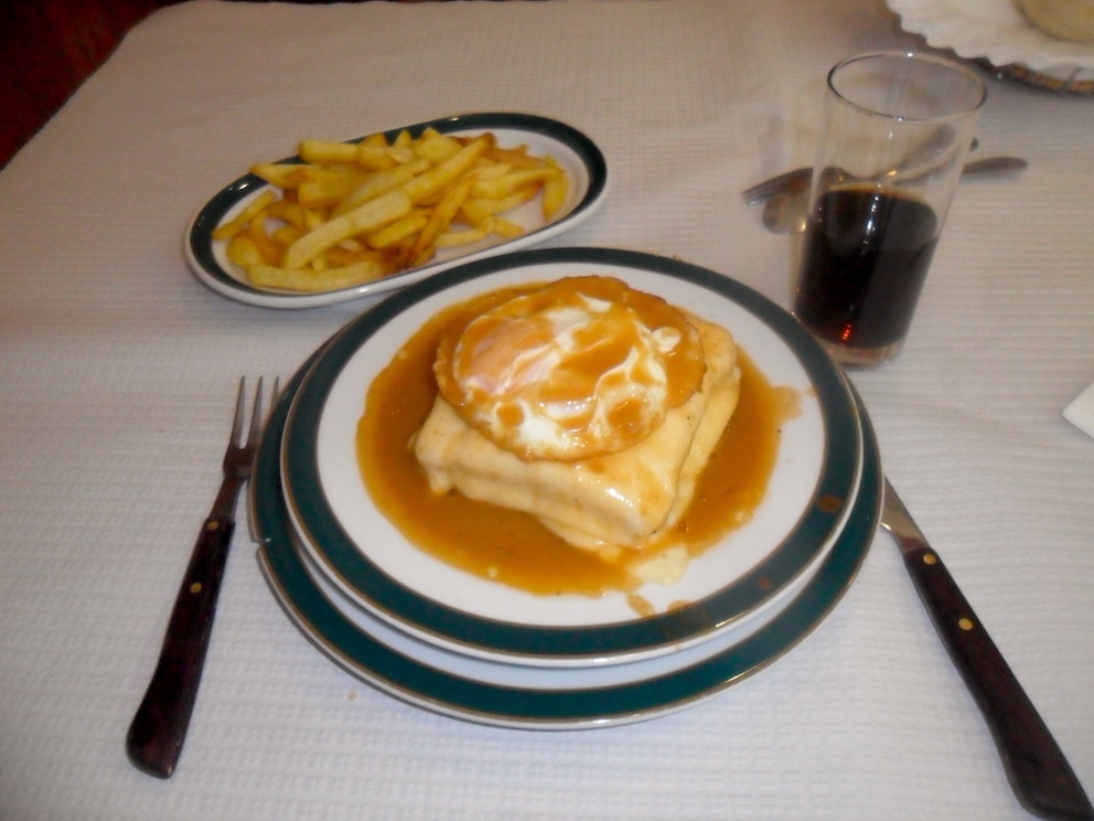 Mehrere Sorten Wurst und Schinken, geschmolzener Käse, Biersoße: Die Francesinha ist ein typisches Gericht in Porto – und eine wahre Kalorienbombe