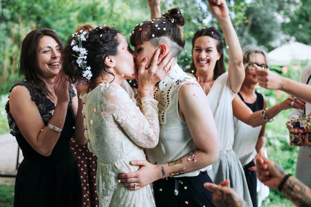 Ein gleichgeschlechtliches Paar küsst sich auf einer Hochzeit