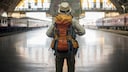 Backpacker mit Rucksack am Bahnhof