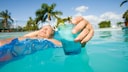 Mann mit Getränk im Pool