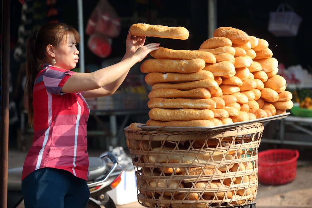 Eine Frau verkauft Binh Mi auf einem Markt in Vietnam