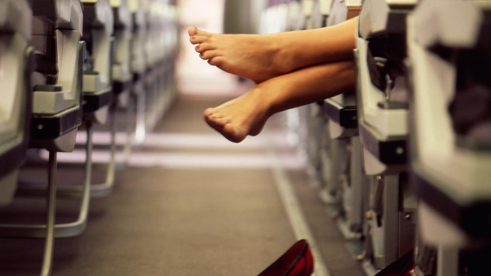Eine Frau barfuß in einem Flugzeug