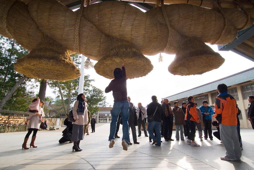  M&uuml;nzwurf unter dem Shimenawa am Izumo-Taisha-Schrein