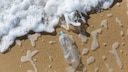 Plastikflasche wird von den Wellen angespült