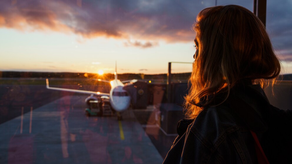Frau schaut auf Flugzeug