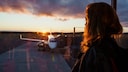Frau schaut auf Flugzeug