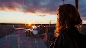 Frau schaut auf Flugzeug