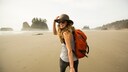 Eine Frau spaziert an einem Strand