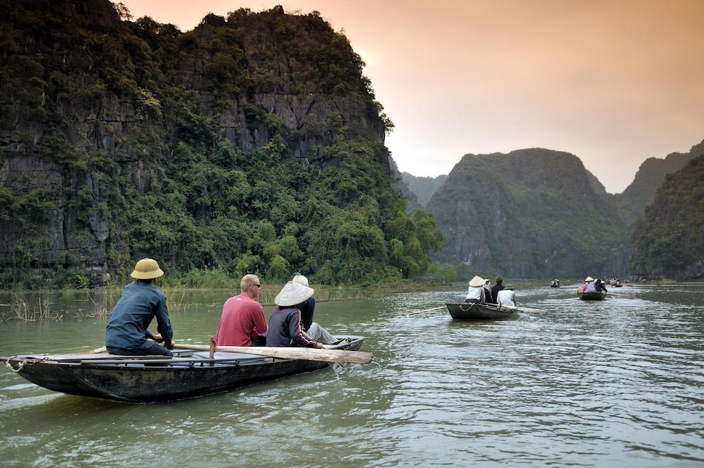 Boote fahren durch die so genannte Trockene Halong-Bucht in der Nähe von Ninh Binh