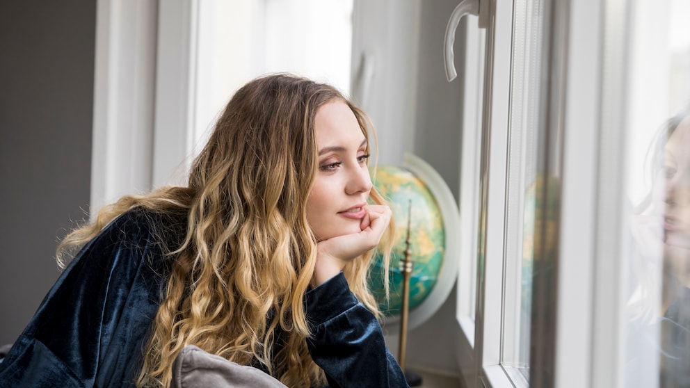 Frau schaut aus dem Fenster