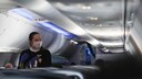 Flugbegleiterin mit Mundschutz im Flugzeug