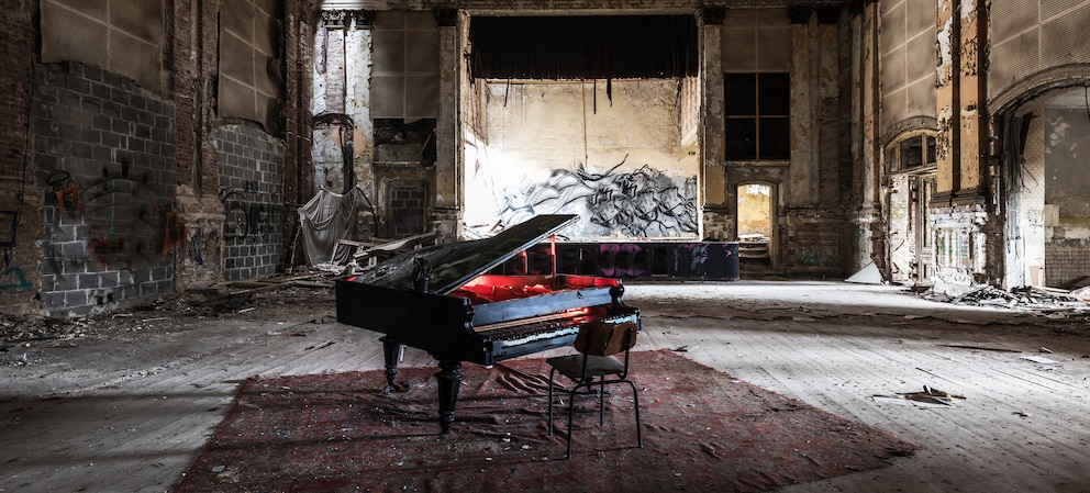 Old piano with red light of a flashlight, in the hall of an old party location (in Berlin). Lost place, meanwhile demolished.