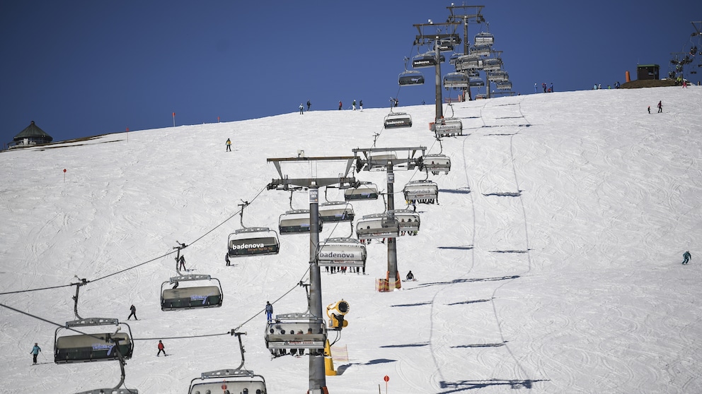 Ein schneebedeckter Hang, über den ein Skilift fährt