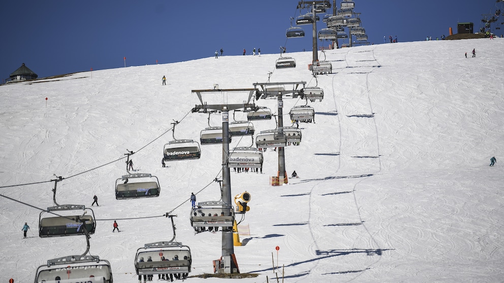 Ein schneebedeckter Hang, über den ein Skilift fährt