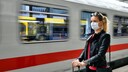 Frau mit Mundschutz am Bahnhof