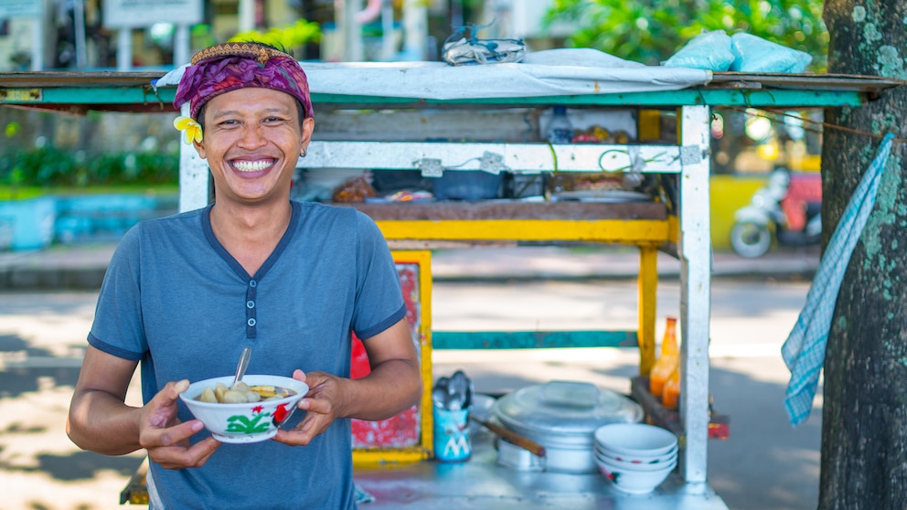 Denpasar，Bali，Indonesien - junger Mann vor seiner Straßenküche