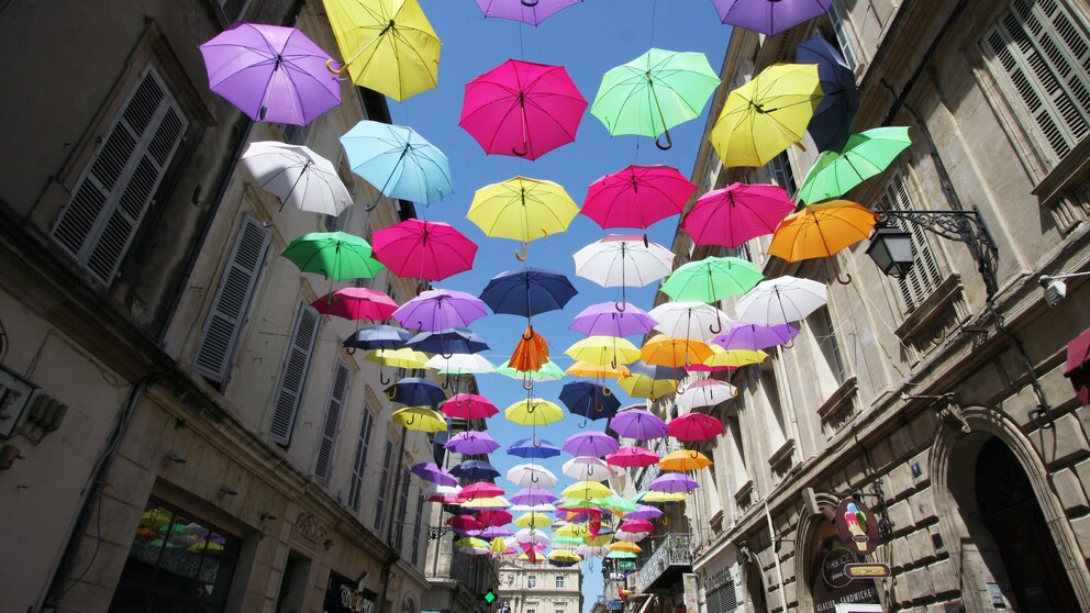 Straße mit farbigen Regenschirmen