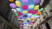 Straße mit farbigen Regenschirmen