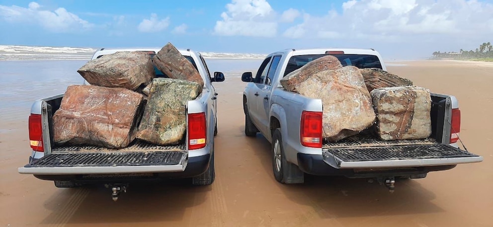 Zwei mit geheimnisvollem Strandgut beladene Pick-ups an der Küste Brasiliens