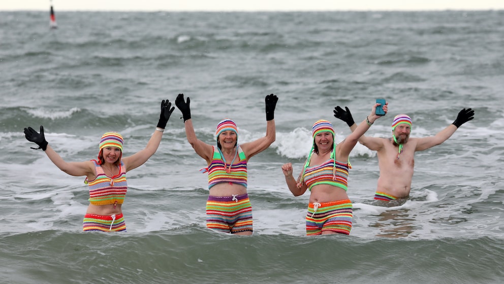 vier Personen gehen in Rostock Eisbaden