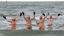 vier Personen gehen in Rostock Eisbaden