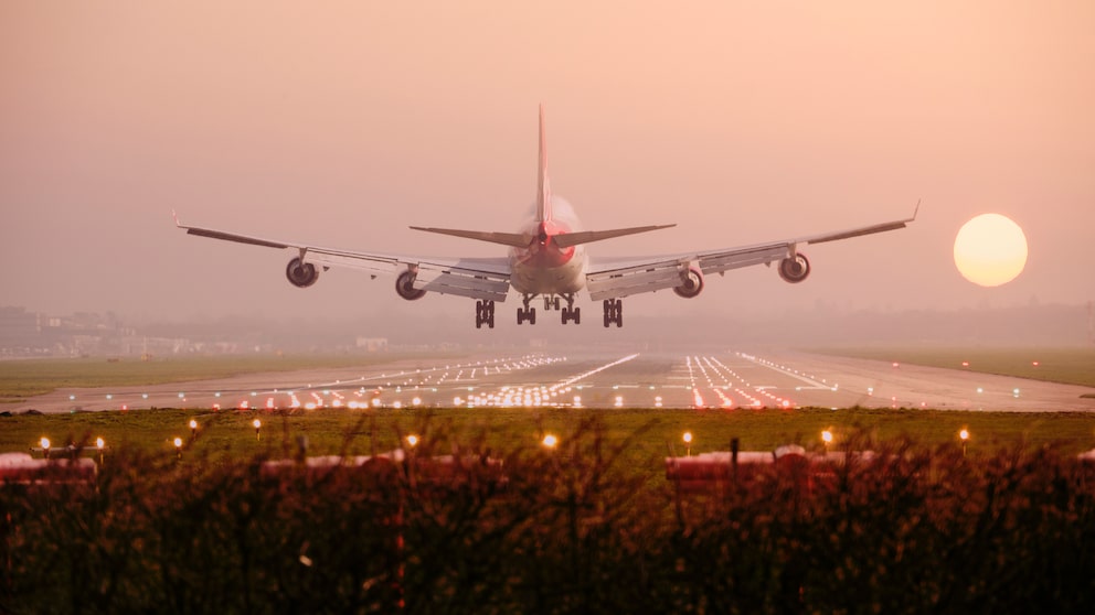 Flugzeug landet in Richtung Sonnenuntergang
