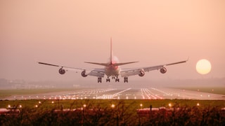 Flugzeug landet in Richtung Sonnenuntergang