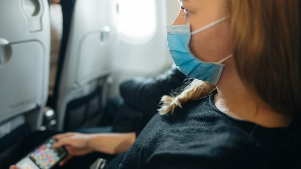 Passagierin auf dem Mittelsitz im Flugzeug