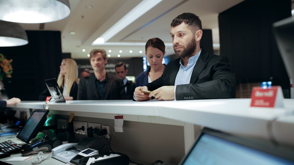 Mann will sein Hotelzimmer beim Check-in bezahlen