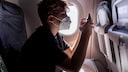 Junge benutzt Smartphone im Flugzeug