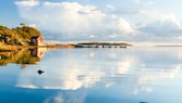 Rote Schwedenhäuschen und glasklare Seen – eine typische Landschaft in dem skandinavischen Land