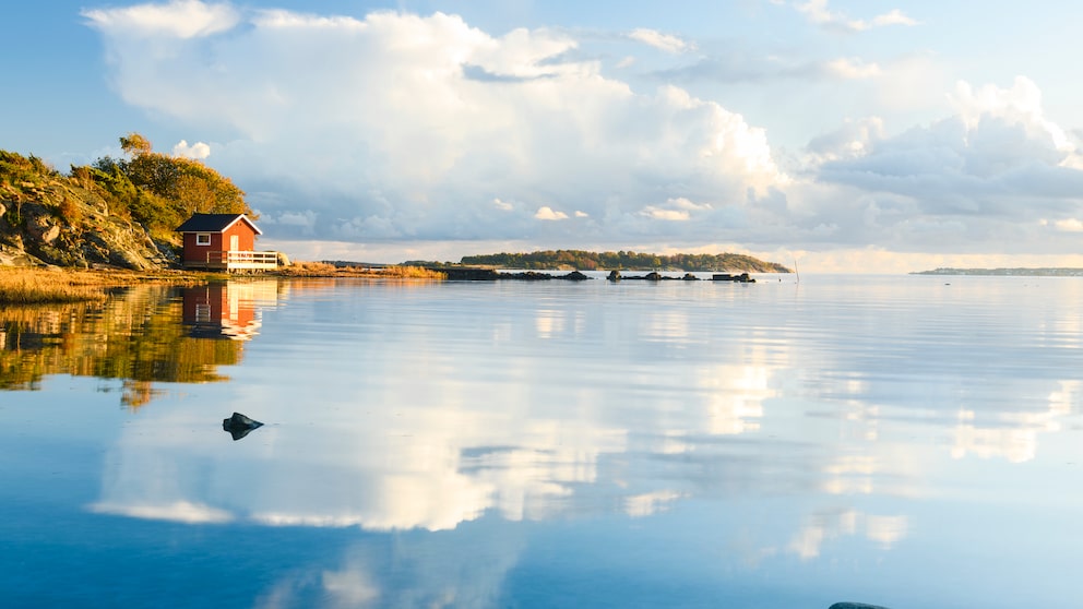 Rote Schwedenhäuschen und glasklare Seen – eine typische Landschaft in dem skandinavischen Land