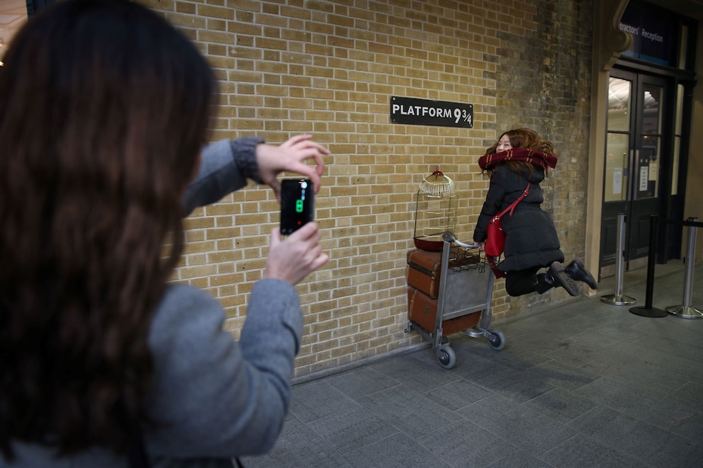 Fans machen Bilder am Gleis 9 3/4 in der King's Cross Station