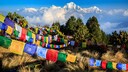 Tibetische Gebetsfahnen auf dem Poon Hill mit Ausblick auf die Spitze des siebthöchsten Bergs der Welt, Dhaulagiri, im Hintergrund