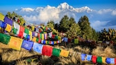 Tibetische Gebetsfahnen auf dem Poon Hill mit Ausblick auf die Spitze des siebthöchsten Bergs der Welt, Dhaulagiri, im Hintergrund