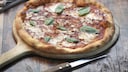 Pizza Margherita auf einem Holzbrett / Pizza-Preise in Europa
