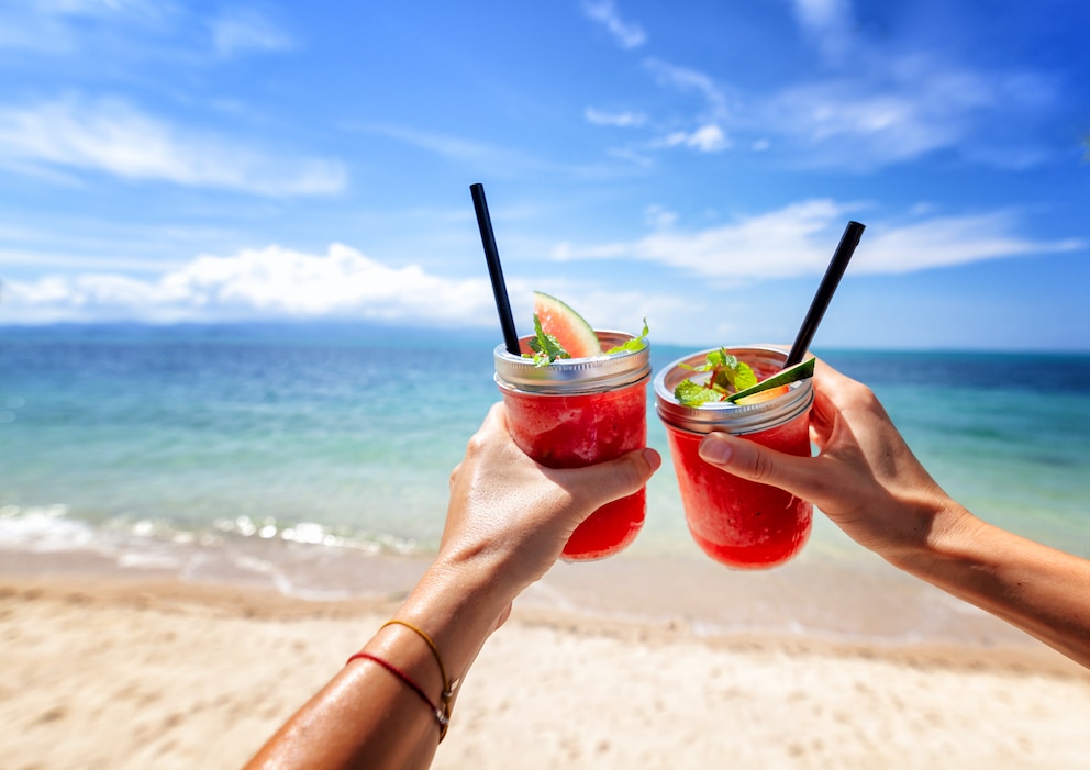 Fresh watermelon juice with a straw in two glasses against a bright tropical landscape, against the background of the sea. Vacation vacations healthy food concept